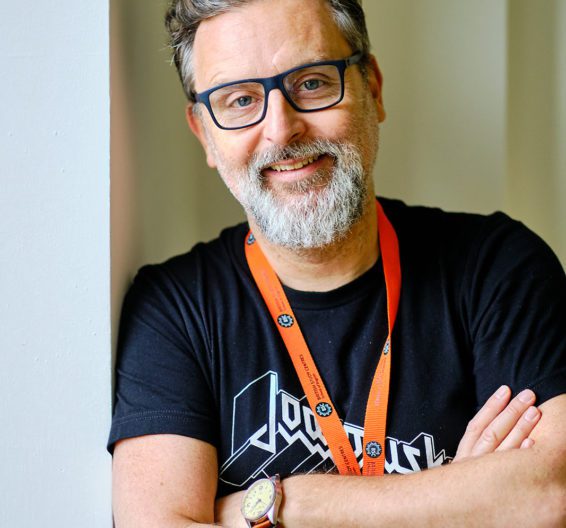 Portrait of a male BSC teacher trainer wearing glasses and a black t-shirt