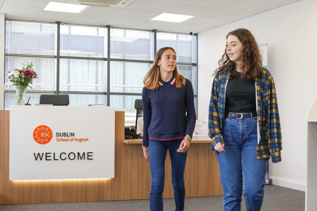 Two teenage girls walk past the modern reception desk at BSC Dublin