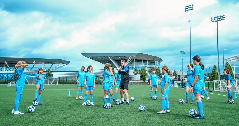Girls being instructed by coach during training session