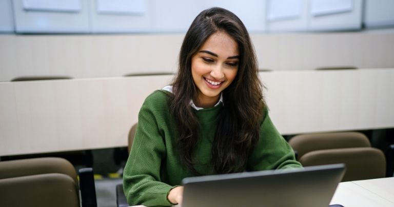 Girl improves her English online at laptop