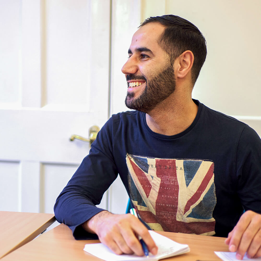 Middle Eastern man learning English with BSC in classroom
