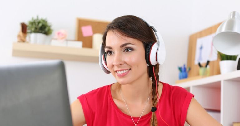 Girl in red top with headphones at laptop learning English