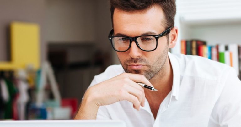 Man in glasses studying intently