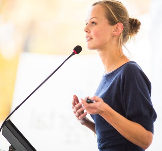 Blonde woman speaking into a microphone