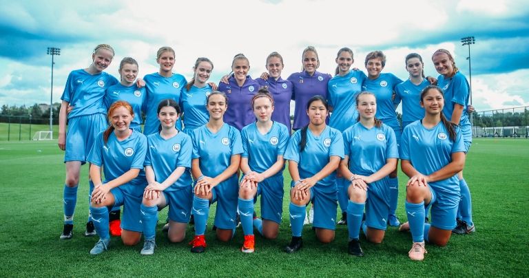 Teenage Girls team posing with players from Manchester City Women's Team