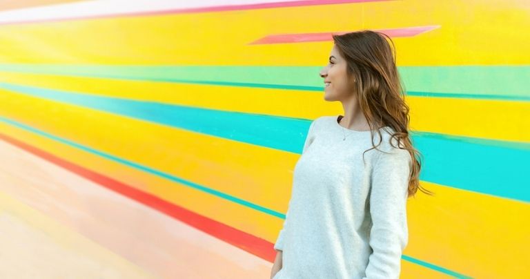 Girl in front of colourful wall