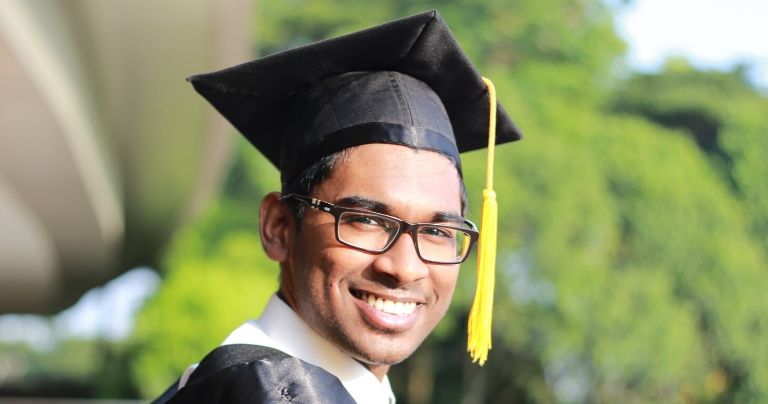Smiling Masters student graduates after university pathways course