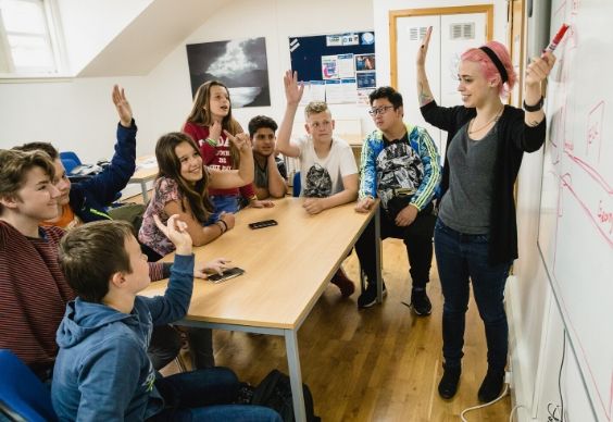 Students raising their hands in class at BSC Edinburgh