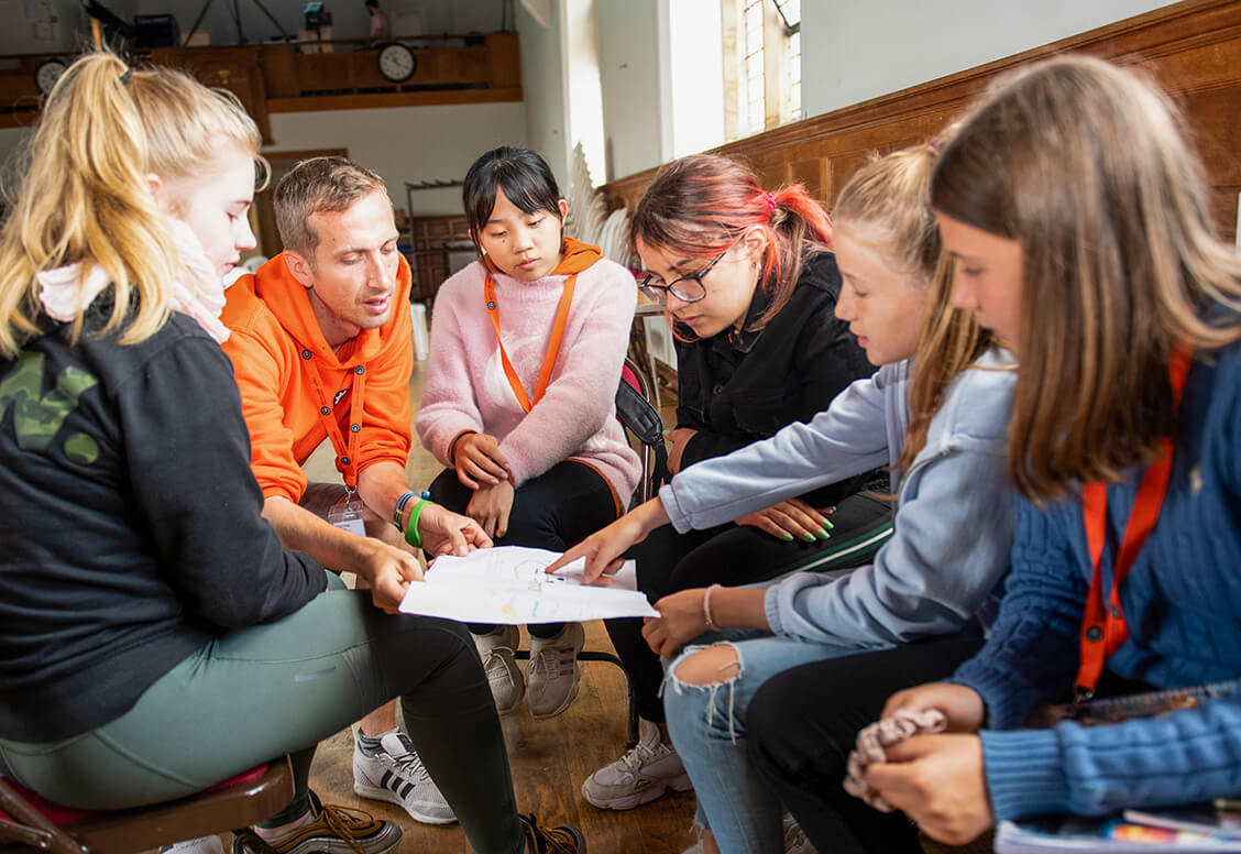 A group of students talking to an adult group leader
